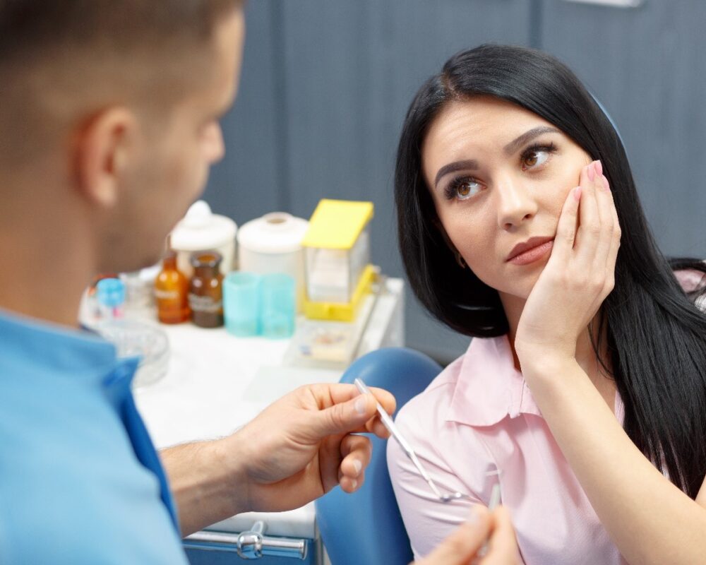 woman with jaw pain talking to dentist